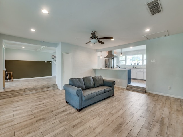 living room with ceiling fan and light hardwood / wood-style flooring