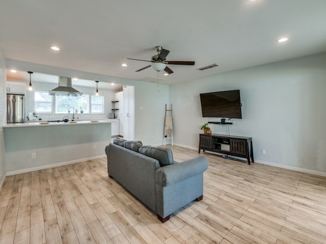 living room with ceiling fan and light wood-type flooring