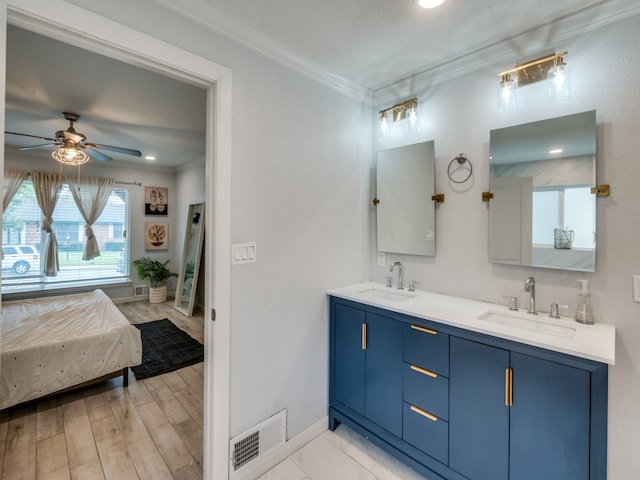 bathroom featuring vanity, hardwood / wood-style flooring, ceiling fan, and ornamental molding