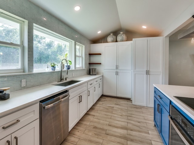 kitchen with white cabinetry, lofted ceiling, sink, and appliances with stainless steel finishes