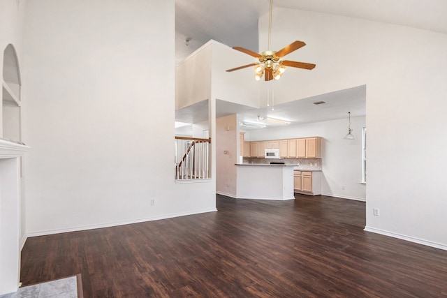 unfurnished living room featuring dark wood-type flooring, ceiling fan, and high vaulted ceiling