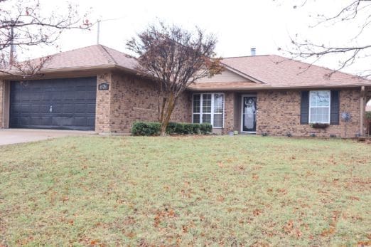 ranch-style home with a front yard and a garage