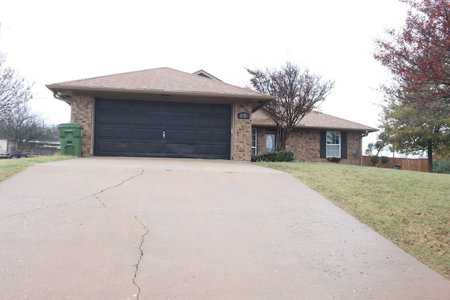 ranch-style house with a garage and a front lawn