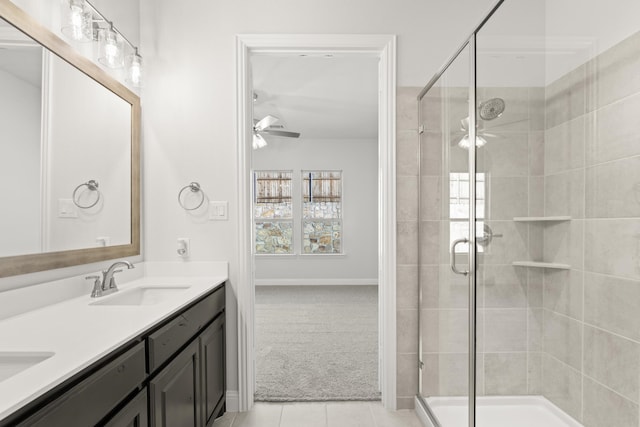 bathroom with vanity, walk in shower, ceiling fan, and tile patterned flooring