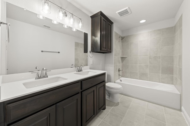 full bathroom featuring tile patterned flooring, vanity, tiled shower / bath combo, and toilet