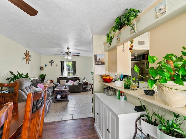 kitchen with a textured ceiling, white cabinets, dark wood-type flooring, and ceiling fan