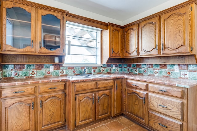 kitchen with light tile patterned flooring, backsplash, tile countertops, and sink