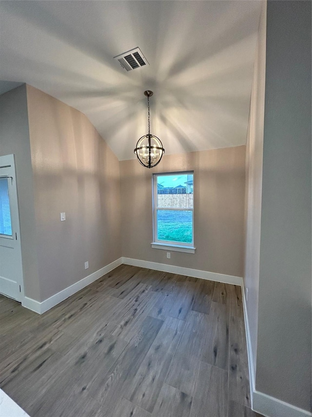 unfurnished room with lofted ceiling, a notable chandelier, wood finished floors, visible vents, and baseboards