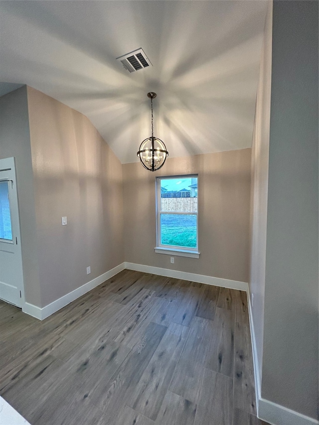 unfurnished dining area with hardwood / wood-style floors, a chandelier, and vaulted ceiling