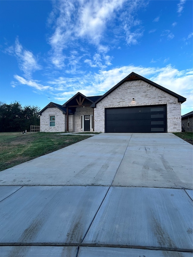 ranch-style house featuring a front lawn and a garage