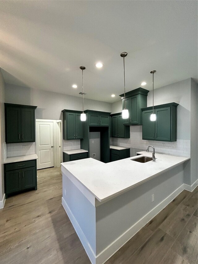 kitchen with tasteful backsplash, sink, ceiling fan, pendant lighting, and light hardwood / wood-style flooring