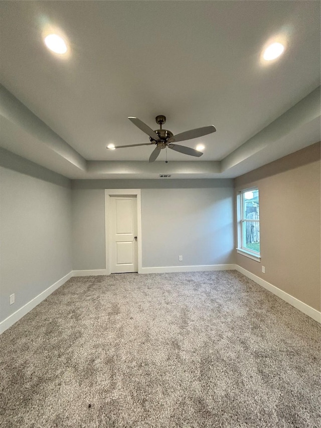 spare room with recessed lighting, carpet floors, a ceiling fan, baseboards, and a raised ceiling