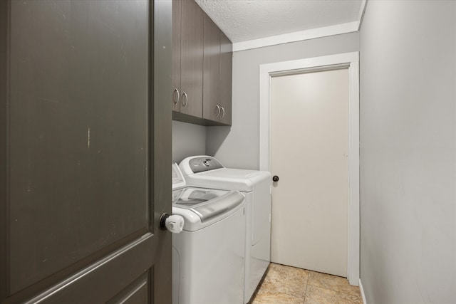 laundry room with cabinets, a textured ceiling, and washing machine and dryer