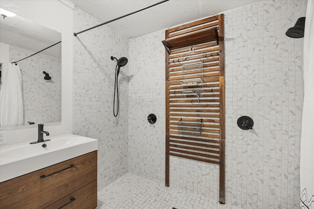 bathroom featuring vanity, a textured ceiling, and walk in shower