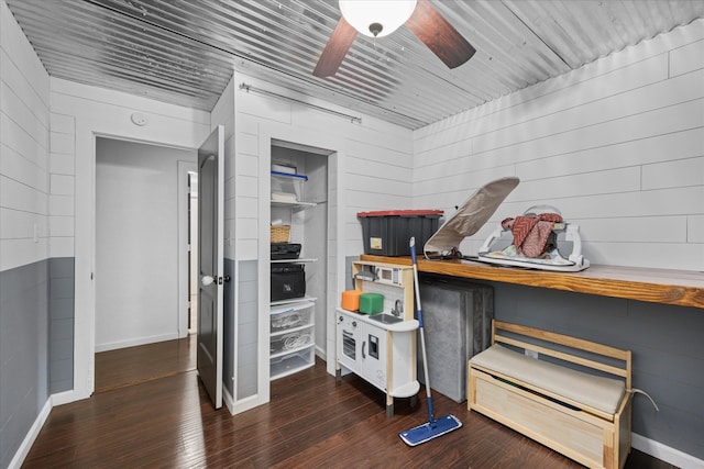 miscellaneous room with wooden walls, ceiling fan, and dark hardwood / wood-style flooring