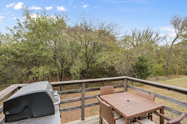 wooden balcony with a wooden deck and a grill