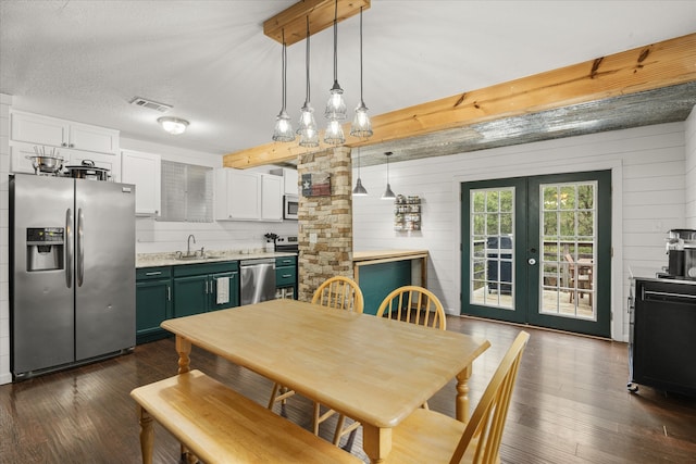 kitchen featuring appliances with stainless steel finishes, sink, green cabinets, pendant lighting, and dark hardwood / wood-style floors