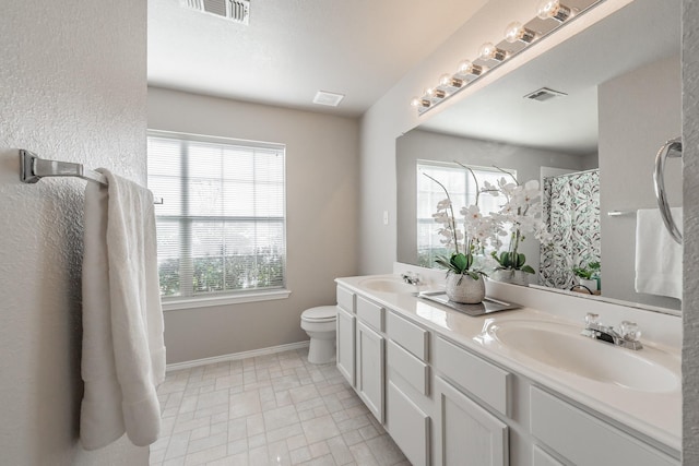 bathroom featuring vanity, toilet, and curtained shower