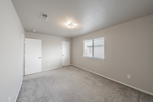 carpeted spare room featuring a textured ceiling