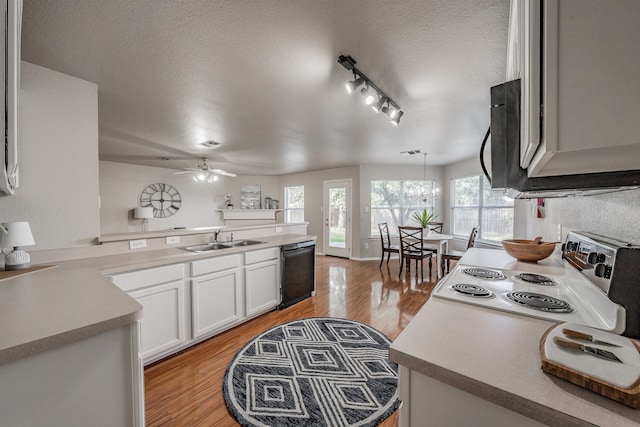 kitchen featuring a textured ceiling, black dishwasher, white range with electric stovetop, and sink