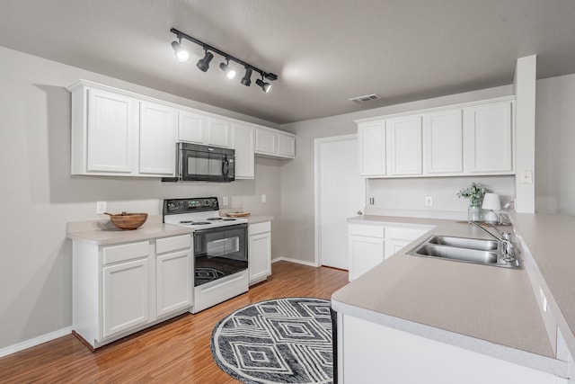 kitchen featuring white cabinets, white electric range, sink, rail lighting, and light hardwood / wood-style floors