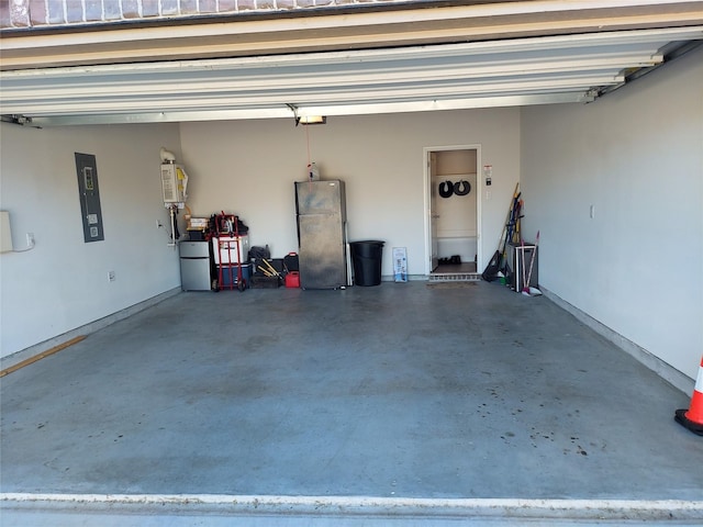 garage with electric panel, a garage door opener, stainless steel refrigerator, and water heater