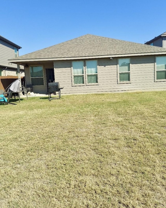 back of property featuring a lawn