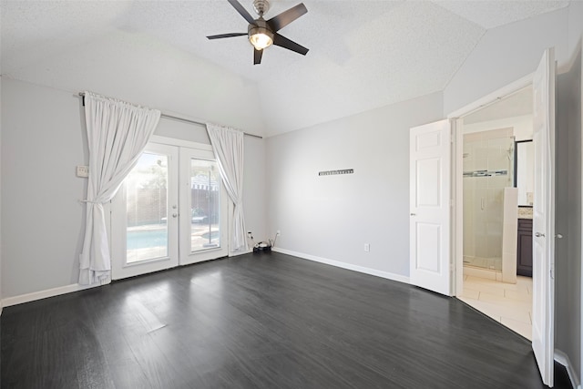 unfurnished room featuring french doors, dark wood-type flooring, vaulted ceiling, a textured ceiling, and ceiling fan