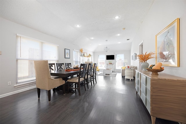 dining space featuring dark wood-type flooring, vaulted ceiling, and a textured ceiling