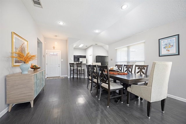 dining area featuring a textured ceiling and dark hardwood / wood-style flooring