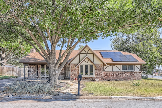 view of front of house featuring solar panels and a front yard