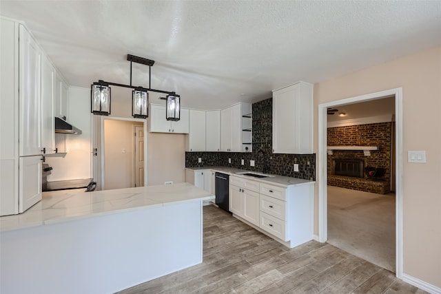 kitchen featuring kitchen peninsula, pendant lighting, white cabinets, range, and black dishwasher