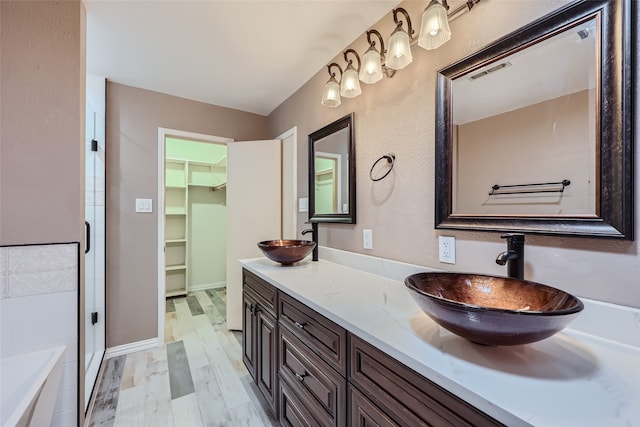 bathroom featuring hardwood / wood-style floors, vanity, and plus walk in shower