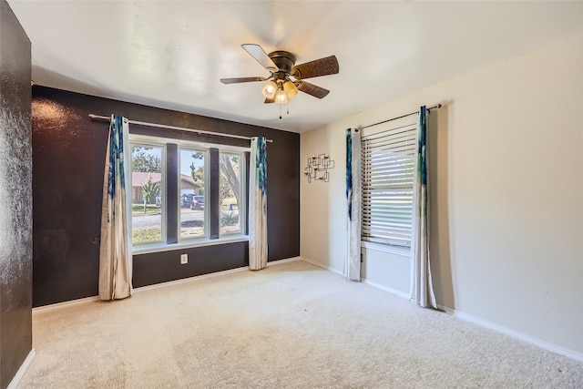 carpeted spare room featuring ceiling fan