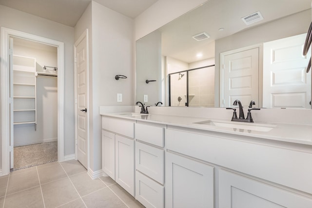 bathroom featuring visible vents, a sink, and a shower stall