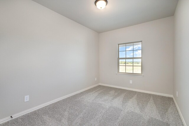 carpeted spare room with baseboards