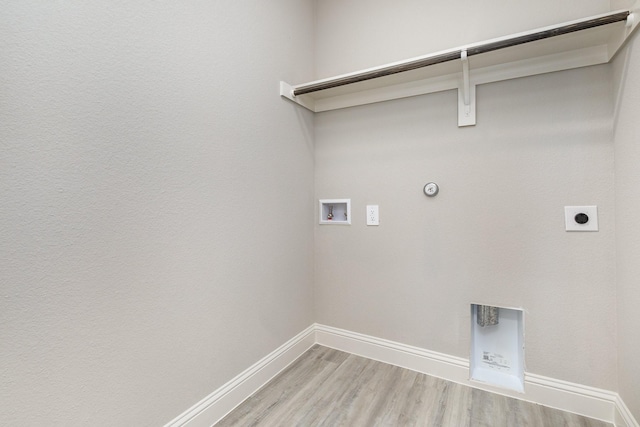 laundry area with hookup for a washing machine, gas dryer hookup, electric dryer hookup, baseboards, and light wood-type flooring