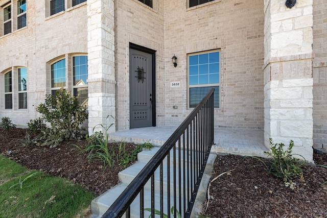 entrance to property featuring brick siding