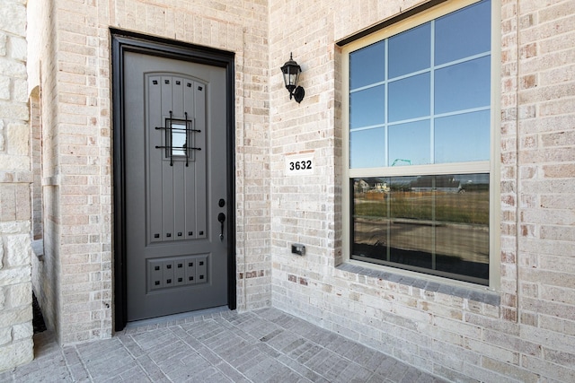 entrance to property featuring brick siding