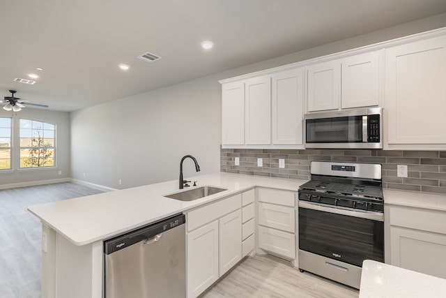 kitchen with appliances with stainless steel finishes, kitchen peninsula, and sink