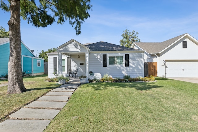 view of front facade with ceiling fan, a front yard, and a garage