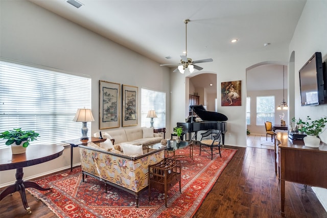 living room with hardwood / wood-style floors, high vaulted ceiling, a healthy amount of sunlight, and ceiling fan with notable chandelier