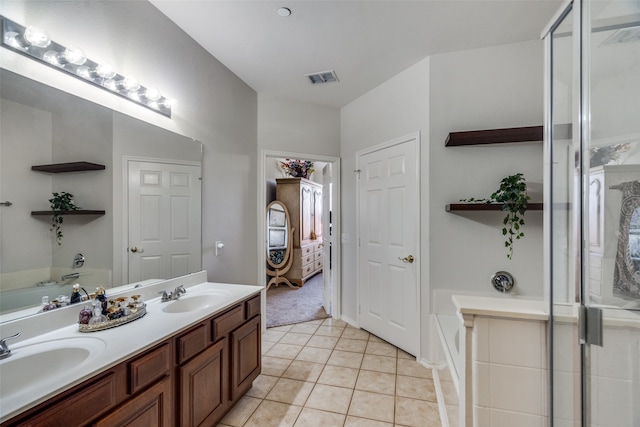 bathroom featuring tile patterned floors, vanity, and a bath