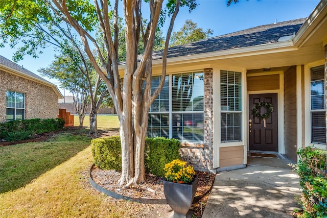 view of exterior entry with a lawn