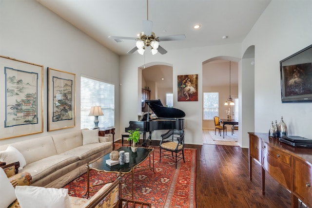 living room with dark hardwood / wood-style floors and ceiling fan with notable chandelier