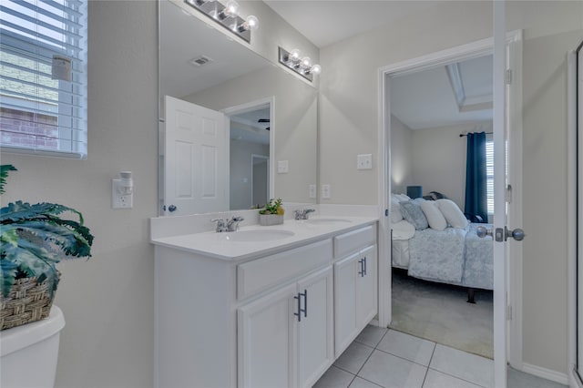 bathroom with toilet, vanity, and tile patterned flooring