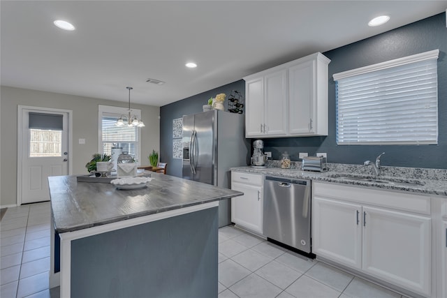 kitchen featuring white cabinets, hanging light fixtures, a kitchen island, a chandelier, and dishwasher