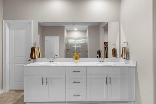 bathroom featuring a shower with door and vanity