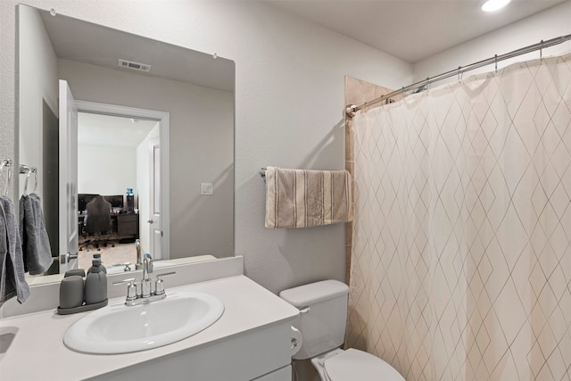 bathroom featuring vanity, toilet, and walk in shower