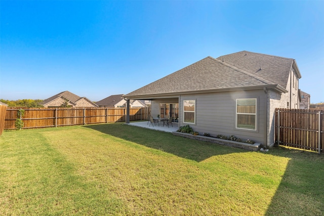 back of house with a patio and a yard